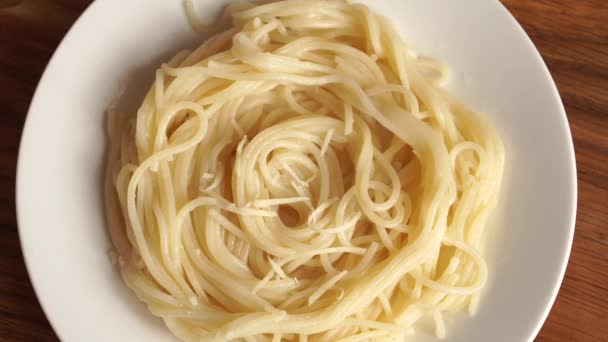 Warme pasta wordt bestrooid met geraspte kaas — Stockvideo