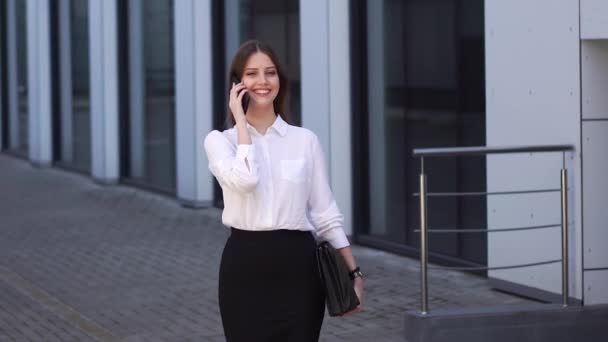 Rapariga sorridente falando em um telefone celular, ouvindo uma mensagem de voz — Vídeo de Stock