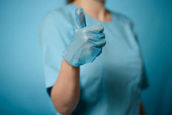 Una mano en un guante médico estéril da un pulgar hacia arriba. — Foto de Stock