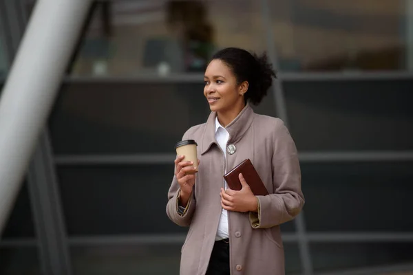 Uśmiechnięta afro-amerykańska bizneswoman stoi przed budynkiem biurowym — Zdjęcie stockowe