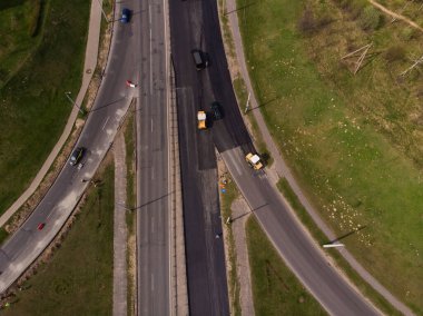 Yeni bir asfalt kaldırım döşeniyor, yol yapım ekipmanları çalışıyor.
