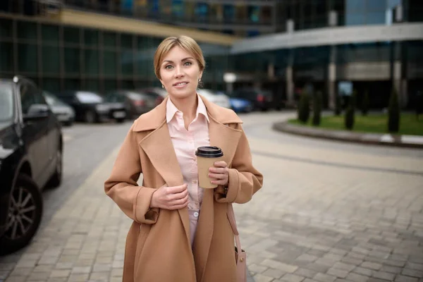 Portret pięknej bizneswoman z kawą w pobliżu centrum biznesowego — Zdjęcie stockowe