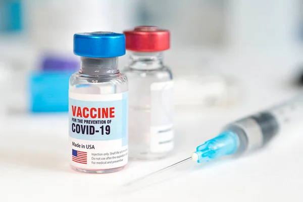 Flacon din sticlă medicală şi seringă din plastic pentru injectare pe masă albă cu fundal albastru. Vaccinarea în Statele Unite ale Americii. Copiați spațiul . — Fotografie, imagine de stoc