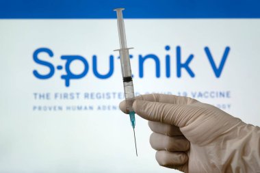Koronovirüs kovid 19 enfeksiyonuna karşı Sputnik V aşısı ve beyaz arka planda bir şırınga. 18 Ocak 2021, Barnaul, Rusya.