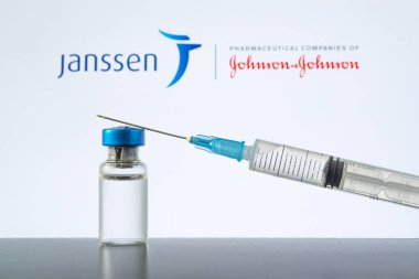 Aşı şırıngası ve mavi zemin üzerinde temiz bir sıvı bulunan cam ampul. Üzerinde de Johnson ve Johnson adlı bir ilaç şirketinin logosu var. 13 Mart, Barnaul, Rusya.