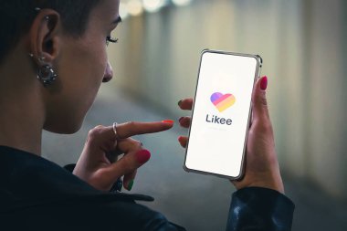 Kız kısa videoları izlemek için akıllı telefonundaki uygulamayı açıyor..