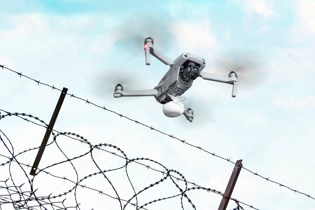 Deliver drugs to the prison using a quadrocopter. A bag of cocaine on a quadrocopter. smuggling of heroin across the border by air with the help of unmanned aerial vehicles. concept