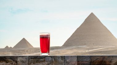 Geleneksel Arap bitkisel çayı, bir bardakta Büyük Şef Khafra Piramitleri ve Giza 'daki Khufu Khufu' nun arka planında. Restoranın güzel manzarası..