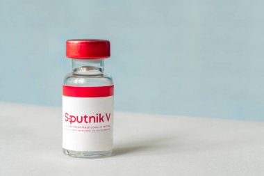 Koronovirüs enfeksiyonundan kaynaklanan Sputnik V aşısı mavi arka planda. 18 Ocak 2021, Barnaul, Rusya.