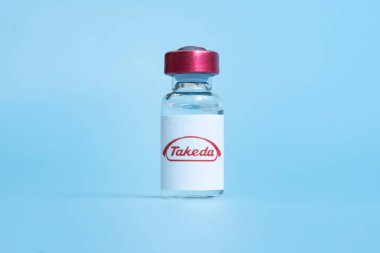 Beyaz bir masada sıvı şişeleri ve büyük ilaç şirketi Takeda 'nın logosu. 15 Mart 2021. Barnaul, Rusya.