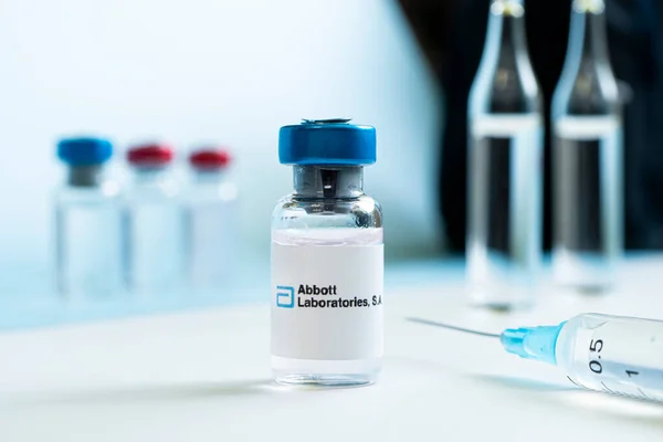 白色桌子上的液体瓶和大型制药公司Abbott Laboratories的标识 2021年3月15日 Barnaul 俄罗斯 — 图库照片
