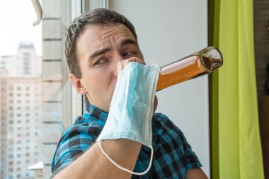 alcoholism, alcohol addiction and people concept - male alcoholic with bottle of rum at home. An unemployed specialist who got drunk alone out of boredom is quarantined in self-isolation. clipart