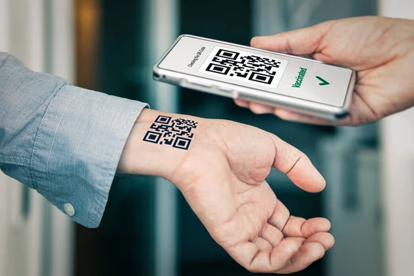 The man shows his hand with a qr code, a confirmation of the vaccination against the covid 19 coronavirus. Temporary tattoo. Scan the QR code using the mobile application. Proof vaccination