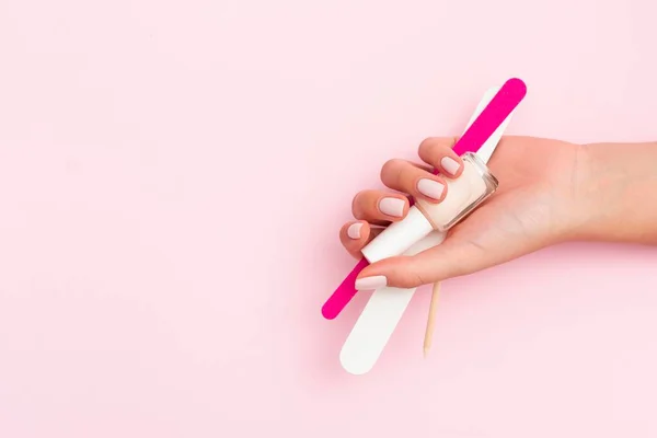 Woman holding manicure tools with copy space