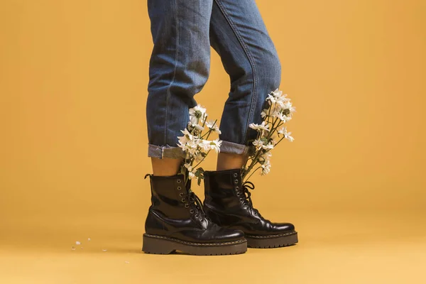 Um homem montado na parte de trás dos sapatos. Pernas de mulher usando botas com flores dentro — Fotografia de Stock