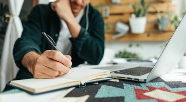 Bilgisayarı ve akıllı telefonu olan yakışıklı bir adam evden uzakta çalışıyor. Uzaktan kumandada serbest çalışan biri. Rahat iş yeri