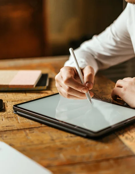 Dijital tablete elektronik kalemle erkek eli çiziminin yakın fotoğrafını çek. Uzaktan çalışan serbest tasarımcı