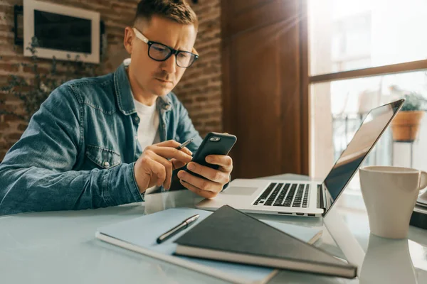 Akıllı telefon ekranını işaret eden adam, sosyal ağlarda sohbet eden, web sitesiyle buluşan, interneti arayan, mesaj gönderen, kısa mesaj çeken ya da online bankacılık kullanan. Erkek ellerine yakın çekim. Uzak çalışma