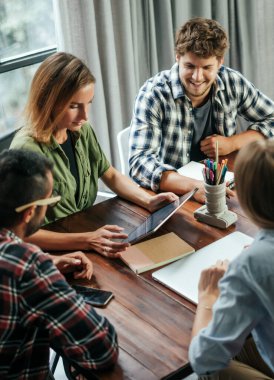 Birlikte çalışan bir grup genç. Modern ofiste yaratıcı iş adamları. Hippi takımı birlikte çalışıyor. Genç modern meslektaşlar. Takım çalışması..