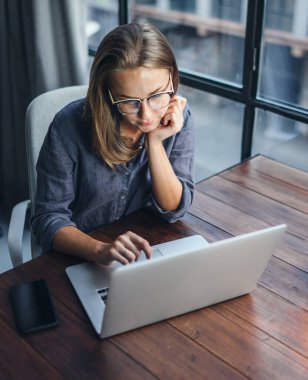 Dizüstü bilgisayarda çalışan genç bir kadın. Uzaktan kumandada serbest çalışan biri. Kız öğrenci çevrimiçi bilgisayar yoluyla öğreniyor. Blogcu ya da gazeteci yeni makale yazıyor.