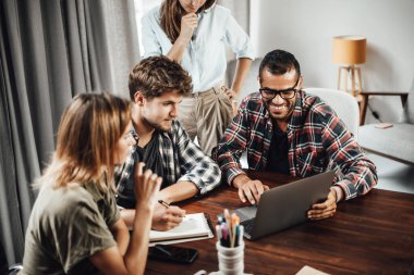 Birlikte çalışan bir grup genç. Modern ofiste yaratıcı iş adamları. Hippi takımı birlikte çalışıyor. Genç modern meslektaşlar. Takım çalışması. Başlangıç konsepti