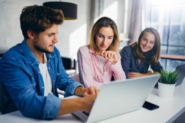 Birlikte çalışan bir grup genç. Modern ofiste yaratıcı iş adamları. Hippi takımı birlikte çalışıyor. Genç modern meslektaşlar. Takım çalışması. Başlangıç konsepti