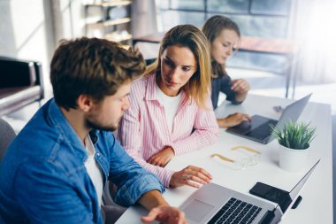 Birlikte çalışan bir grup genç. Modern ofiste yaratıcı iş adamları. Hippi takımı birlikte çalışıyor. Genç modern meslektaşlar. Takım çalışması. Başlangıç konsepti