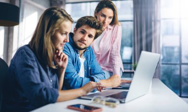 Birlikte çalışan bir grup genç. Modern ofiste yaratıcı iş adamları. Hippi takımı birlikte çalışıyor. Genç modern meslektaşlar. Takım çalışması. Başlangıç konsepti