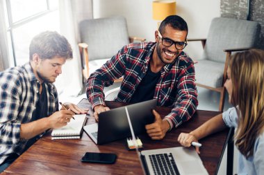 Birlikte çalışan bir grup genç. Modern ofiste yaratıcı iş adamları. Hippi takımı birlikte çalışıyor. İş arkadaşları iş başında..