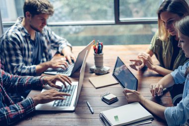 Birlikte çalışan bir grup genç. Modern ofiste yaratıcı iş adamları. Hippi takımı birlikte çalışıyor. İş arkadaşları iş başında..