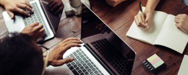 Birlikte çalışan bir grup genç. Modern ofiste yaratıcı iş adamları. Hippi takımı birlikte çalışıyor. Bağımsızlar iş başında. Erkek ellerinin dizüstü bilgisayarla yakın plan görüntüleri..