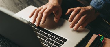 Erkek ellerinin dizüstü bilgisayarlı fotoğrafını çek. Bilgisayarda yazan adam