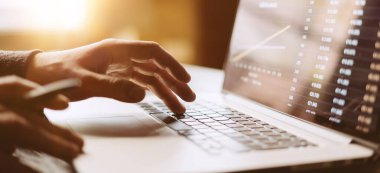 Dizüstü bilgisayarlı erkek ellerinin yakın plan fotoğrafı. İnsanlar evlerinde uzaktan çalışıyor. Uzaklık işi