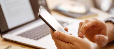 Dizüstü bilgisayarlı erkek ellerinin yakın plan fotoğrafı. İnsanlar evlerinde uzaktan çalışıyor. Uzaklık işi