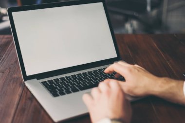 Erkek elleri ve dizüstü bilgisayarı boş ekranlı. Bilgisayar monitörünün kopyası. Kopyalama alanı tasarım ya da metin için hazır.