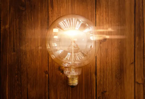 Glowing bulb. Idea, uniqueness, leadership and difference concept. Wood background.