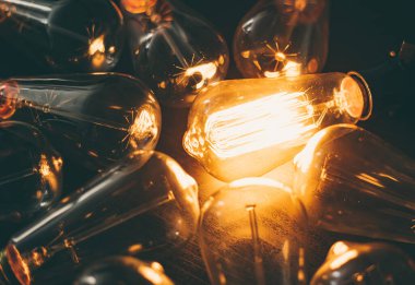 Parlayan ampul. Fikir, eşsizlik, liderlik ve farklı kavramlar. Ahşap arkaplan.