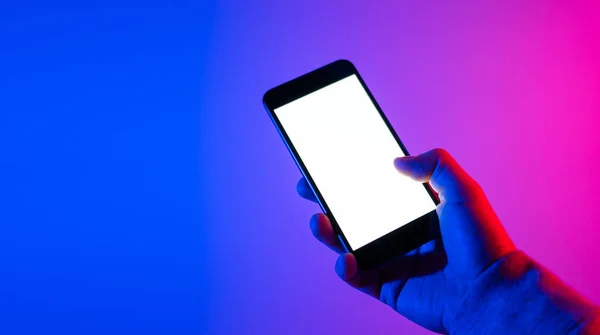 Akıllı telefonlu bir erkek. Boş beyaz ekran. Model-up. Kırmızı ve mavi neon ışık.