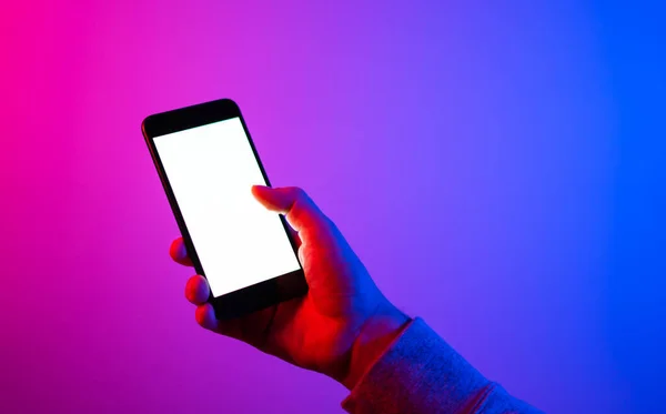 Akıllı telefonlu bir erkek. Boş beyaz ekran. Model-up. Kırmızı ve mavi neon ışık.