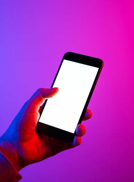 Akıllı telefonlu bir erkek. Boş beyaz ekran. Model-up. Kırmızı ve mavi neon ışık.