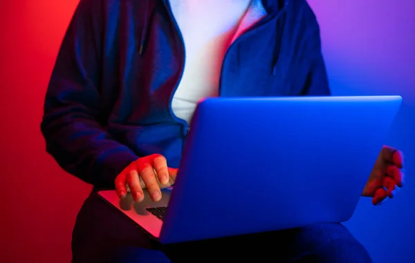 Laptoplu genç adam. Kırmızı ve mavi neon ışık