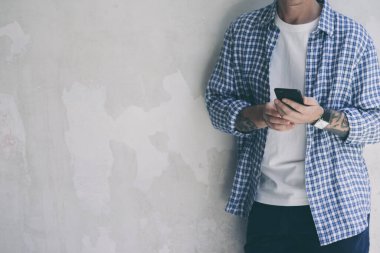 Akıllı telefon ekranını işaret eden, sosyal ağlarda sohbet eden, web sitesiyle buluşan, interneti arayan, mesaj gönderen, mesaj veya internet bankacılığı kullanan genç bir adam. Cep telefonuyla erkek ellerini kapat