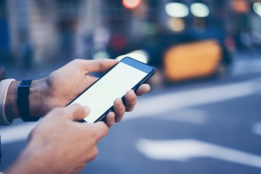Erkek elinin boş ekranlı modern akıllı telefonu tutarken yakın plan görüntüsü. Model mesaj ya da içerik için hazır. Cep telefonlu bir adamın elleri. Boş ekran. Gece Caddesi, Bokeh Light