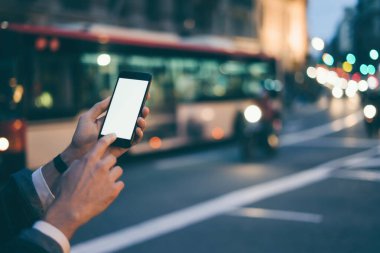 Erkek elinin boş ekranlı modern akıllı telefonu tutarken yakın plan görüntüsü. Model mesaj ya da içerik için hazır. Cep telefonlu bir adamın elleri. Boş ekran. Gece Caddesi, Bokeh Light