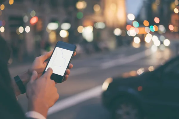 Akıllı telefonla erkek ellerini kapat. Şehrin hedef adresine gitmek için uygulama ekranında GPS harita navigasyonu kullanan bir turist. Seyahat ve teknoloji konsepti