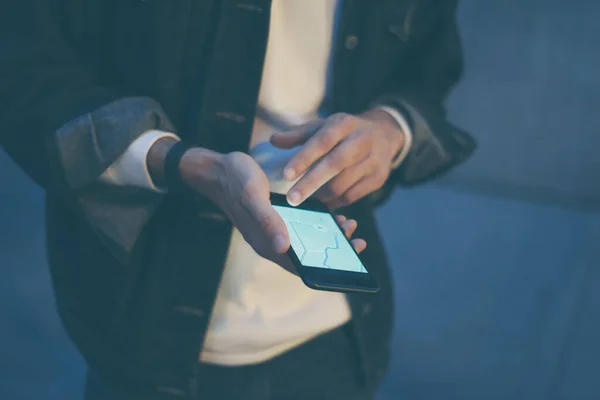 Close up of male hands with smartphone. Tourist using GPS map navigation on application screen for direction to destination address in the city. Travel and technology concept