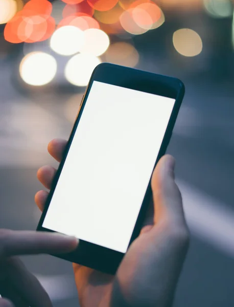 Erkek elinin boş ekranlı modern akıllı telefonu tutarken yakın plan görüntüsü. Model mesaj ya da içerik için hazır. Cep telefonlu bir adamın elleri. Boş ekran. Gece Caddesi, Bokeh Light