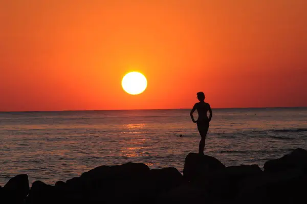 Gün batımında kadın silueti