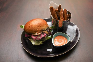 Kırmızı soğanlı ve portobello mantarlı leziz sığır etli çizburger ve patates kızartması ve soslu portobello mantarı..