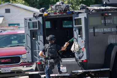 Reseda, California, ABD - 24 Şubat 2021: LAPD SWAT ekibi, polis memurları ve LAFD itfaiyecileri ve helikopterleri Reseda 'daki bir silahlı adam ihbarına yanıt verdiler. Şüphelilerden biri gözaltına alındı..